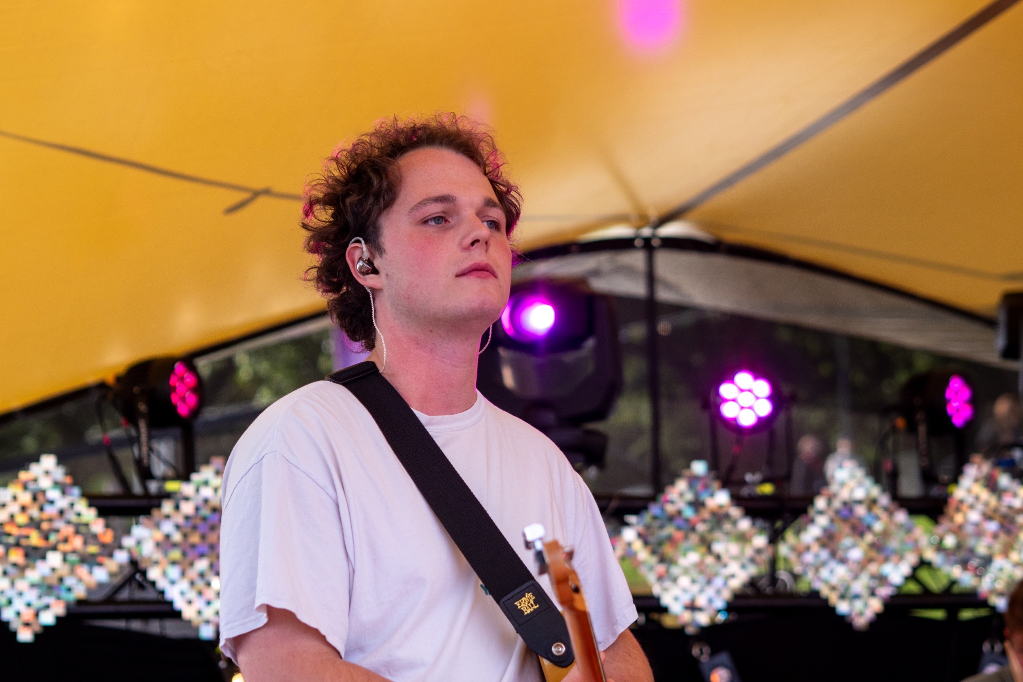 Guitarist on an outdoor stage under warm lights.