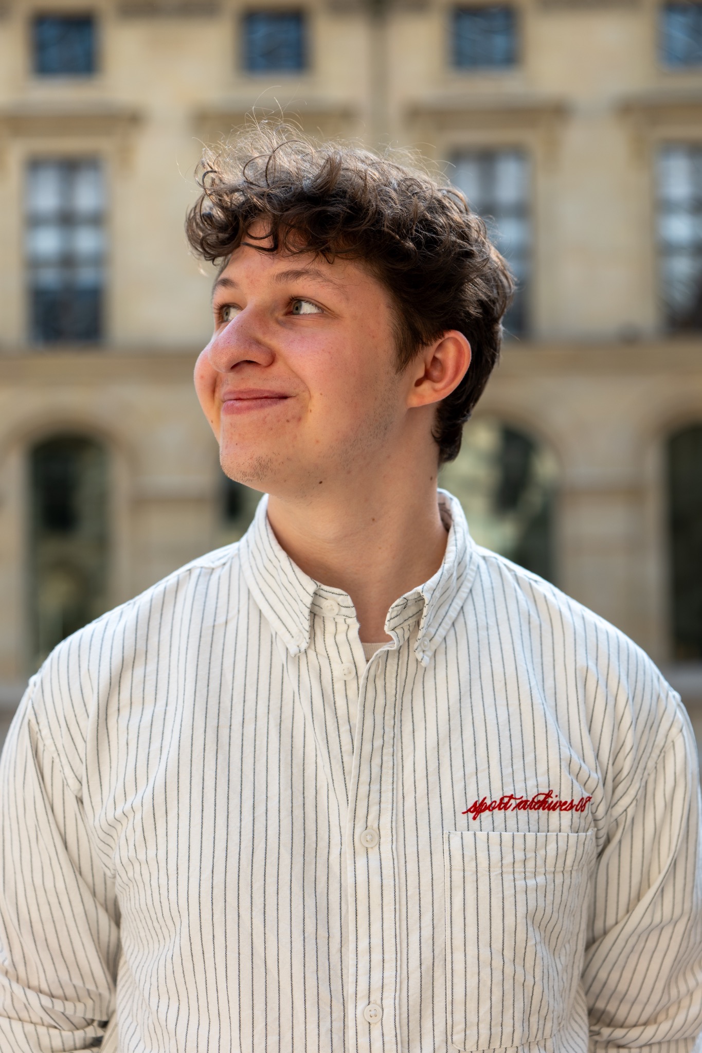 Young man in a light shirt photographed in Paris.