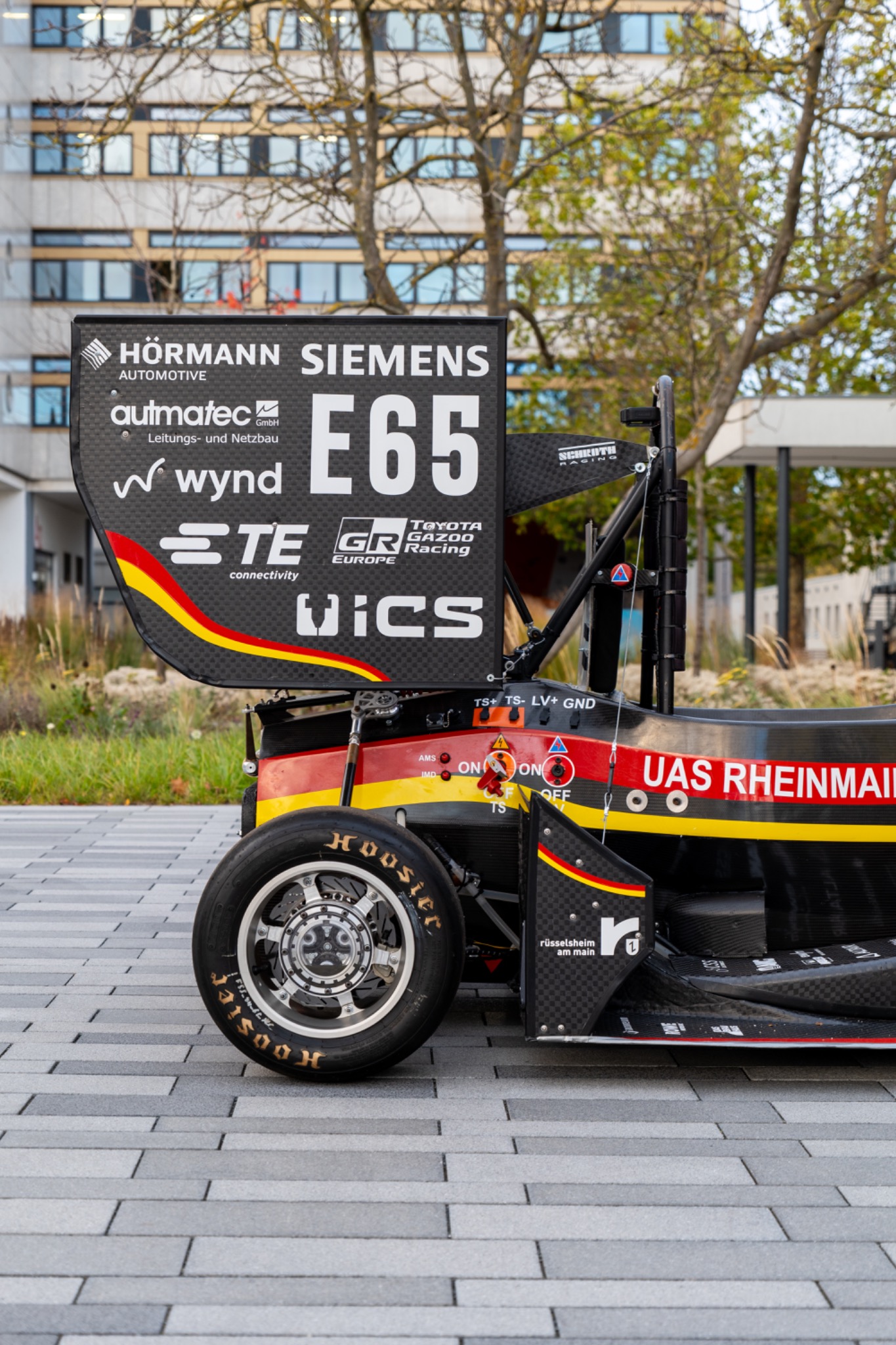 Detail of a racing car displayed on a city street.